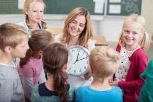 Lehrerin erklärt Schülern die Uhr