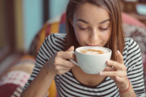 junge Frau trinkt Cappuccino