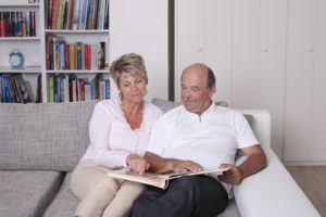 Älteres Ehepaar schaut Fotobuch an